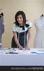 Beautiful young woman working in fashion studio