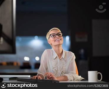 beautiful young woman working on computer at night in dark office. The designer works in the later time.