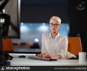 beautiful young woman working on computer at night in dark office. The designer works in the later time.