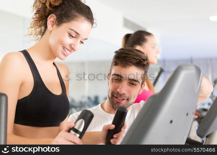 Beautiful young woman working out at the gym with the help of her personal trainer