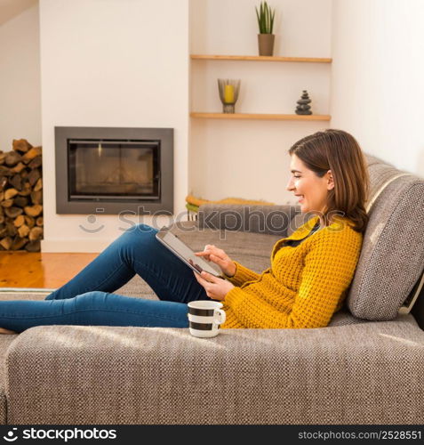 Beautiful young woman working with a tablet at home