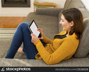 Beautiful young woman working with a tablet at home