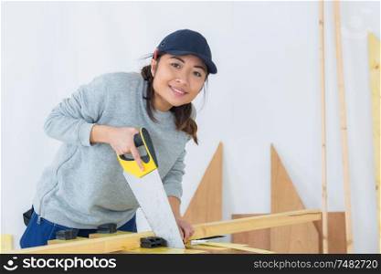 beautiful young woman working with saw