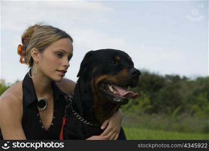 beautiful young womand and her purebred rottweiler