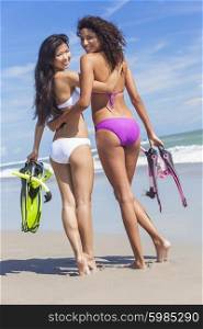 Beautiful young women girls in bikinis with diving equipment on a beach