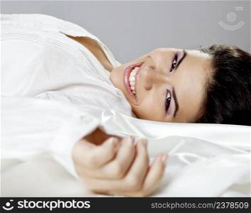 Beautiful young women lying on the bed and smilling
