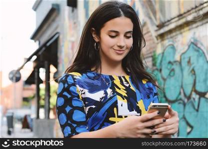 beautiful young women sending message with smartphone on the street.