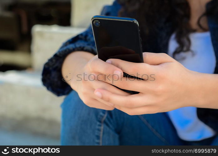 beautiful young women sending message with smartphone on the street.