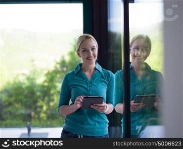 beautiful young women using tablet computer by the window of her luxury home