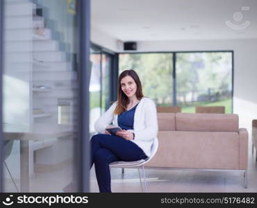 beautiful young women using tablet computer by the window of her luxury home