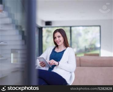 beautiful young women using tablet computer by the window of her luxury home