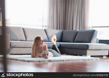 beautiful young women using tablet computer on the floor of her luxury home