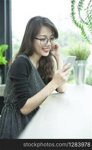 beautiful younger asian woman toothy smiling face happiness emotion reading message on smart phone