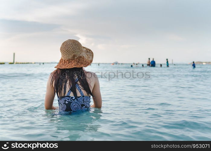 Beautifull sandy beach and blue sky in summer with women sitting on the beach.