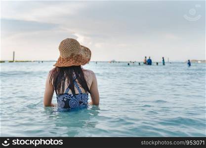 Beautifull sandy beach and blue sky in summer with women sitting on the beach.
