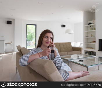 Beautifull young woman in a bathrobe enjoying morning coffee in her luxurious home villa