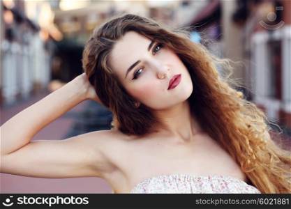 Beautifull young woman showing off her recently depilated and smooth armpits. Fashion portraite of a model with long curly healthy hair, ombre