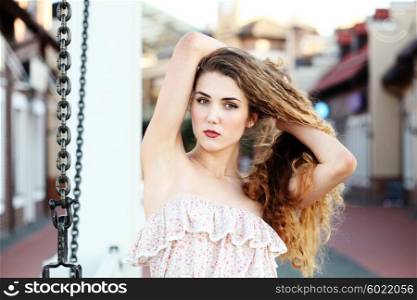 Beautifull young woman showing off her recently depilated and smooth armpits. Fashion portraite of a model with long curly healthy hair, ombre