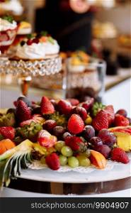 Beautifully decorated catering banquet table with different fresh fruits and sweet on corporate birthday party event or wedding celebration.. Beautifully decorated catering banquet table with different fresh fruits and sweet on corporate birthday party event or wedding celebration