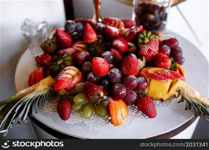 Beautifully decorated catering banquet table with different fresh fruits on corporate birthday party event or wedding celebration.. Beautifully decorated catering banquet table with different fresh fruits on corporate birthday party event or wedding celebration