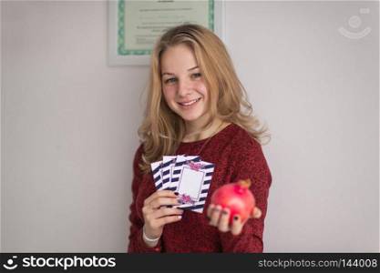 Beautifully decorated winning tickets in the hands of a young girl.. A pretty girl in a sweater holding in his hand the gift tickets 9041.