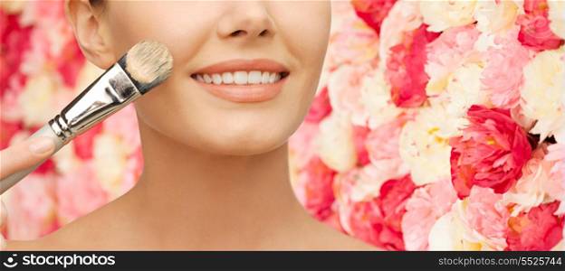 beauty amd make-up concept - closeup picture of beautiful woman with brush applying cream foundation