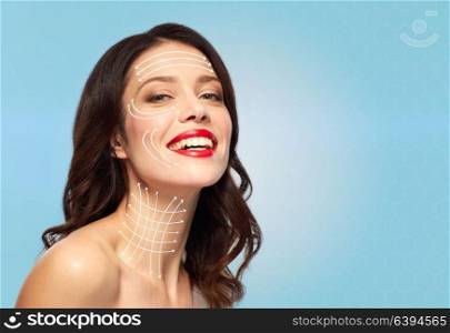beauty and anti-age concept - happy young woman with lifting arrows on face and neck skin over blue background. woman with lifting arrows on face and neck skin