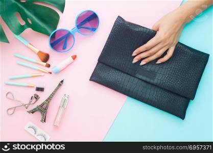 Beauty and cosmetic items, fashion sunglasses and woman hand hol. Beauty and cosmetic items, fashion sunglasses and woman hand holding clutch bag on pastel color background