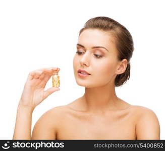 beauty and cosmetology concept - beautiful woman showing bottle with golden dust