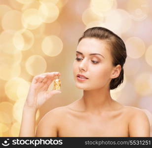 beauty and cosmetology concept - beautiful woman showing bottle with golden dust