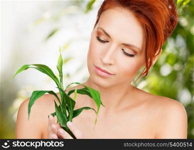 beauty and eco cosmetology concept - beautiful woman on nature with green sprout
