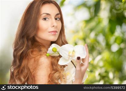 beauty and eco cosmetology concept - beautiful woman with orchid flower