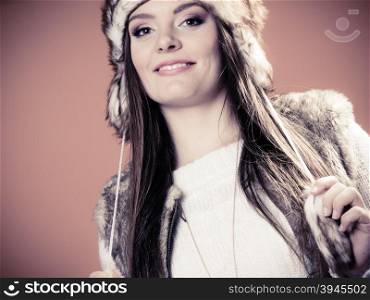 Beauty and fashion of women. Wintertime. Portrait of attractive young girl in fur winter cap hat. Studio shot.