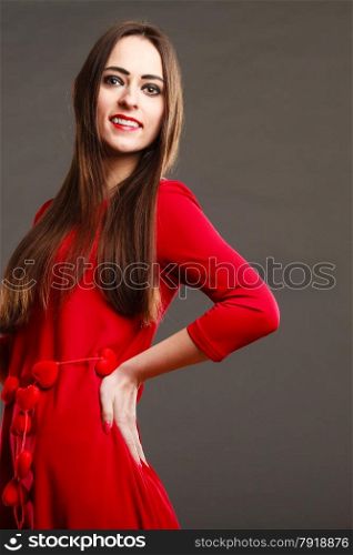 Beauty and fashion. Woman portrait. Attractive young female in red on gray background in studio.