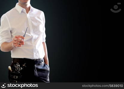 beauty and hair salon, hairstyle and people concept - close up of male stylist with scissors over blank black background