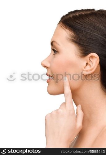 beauty and health concept - smiling young woman pointing to her cheek