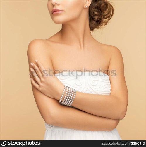 beauty and jewelery concept - beautiful woman with pearl earrings and bracelet