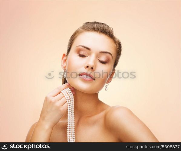beauty and jewelery concept - beautiful woman with pearl earrings and necklace