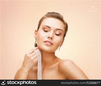 beauty and jewelery concept - beautiful woman with pearl earrings and necklace
