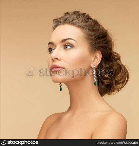 beauty and jewelry concept - beautiful woman in diamond and emerald earrings
