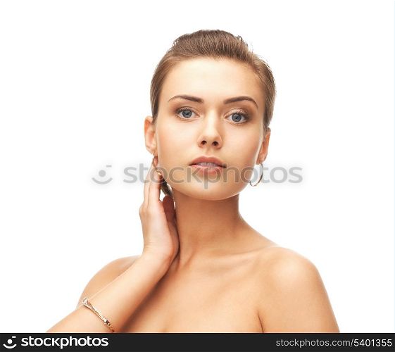 beauty and jewelry concept - beautiful woman wearing gold earrings and bracelet