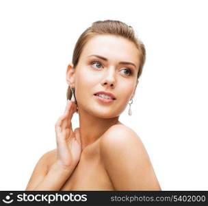 beauty and jewelry concept - beautiful woman wearing shiny diamond earrings
