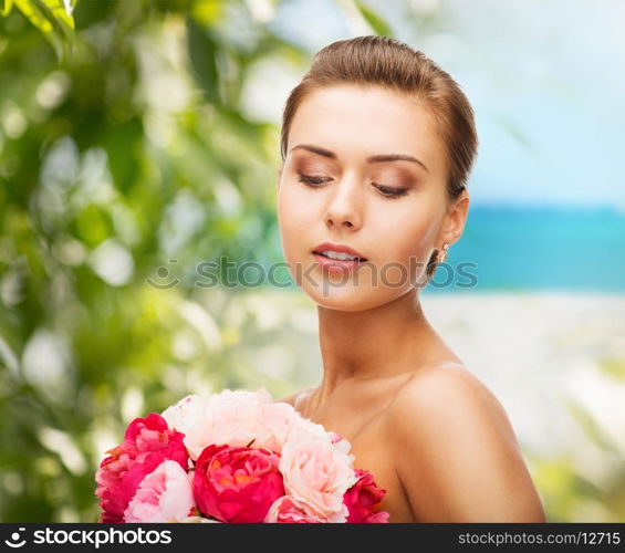 beauty and jewelry concept - woman wearing earrings and holding flowers