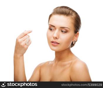 beauty and jewelry concept - woman wearing shiny diamond earrings