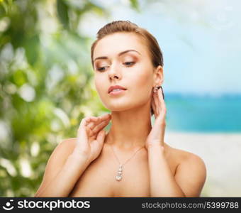 beauty and jewelry concept - woman wearing shiny diamond earrings