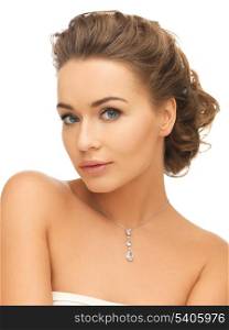 beauty and jewelry concept - woman wearing shiny diamond pendant