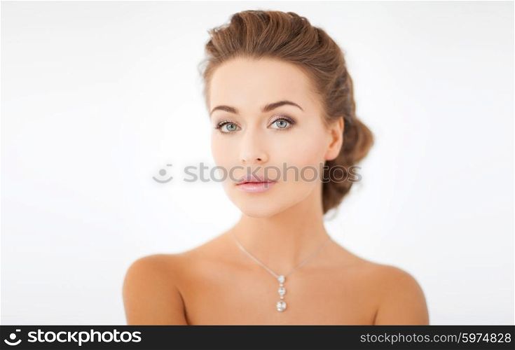 beauty and jewelry concept - woman wearing shiny diamond pendant. woman wearing shiny diamond pendant