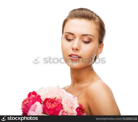 beauty and jewelry - woman wearing earrings and holding flowers
