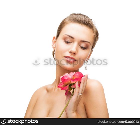 beauty and jewelry - woman with diamond earrings, ring and flower