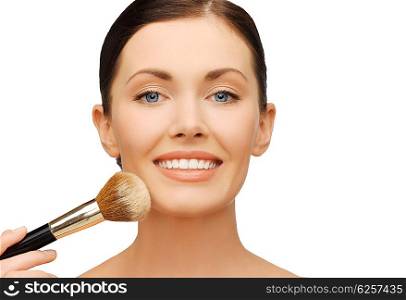 beauty and make-up concept - woman applying powder foundation with brush. woman applying powder foundation with brush